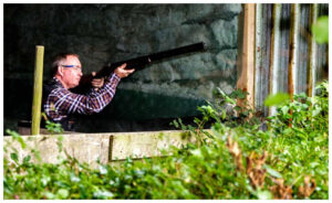 A man aiming a shotgun.